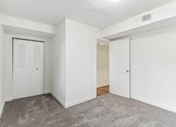 a room with white walls and a carpet and a closet at Oaks at Oxon Hill, Oxon Hill, Maryland
