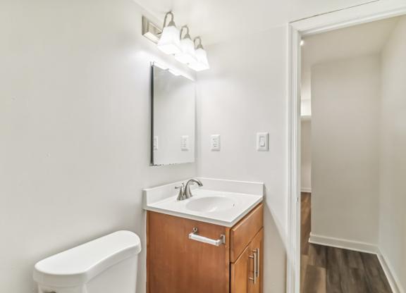 a bathroom with a sink and a mirror and a toilet at Oaks at Oxon Hill, Oxon Hill, Maryland