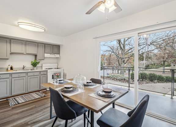 a living room with a large window and a table with chairs at Oaks at Oxon Hill, Oxon Hill, Maryland