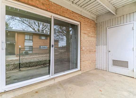 the patio of a building with sliding glass doors and a fence at Oaks at Oxon Hill, Oxon Hill, Maryland