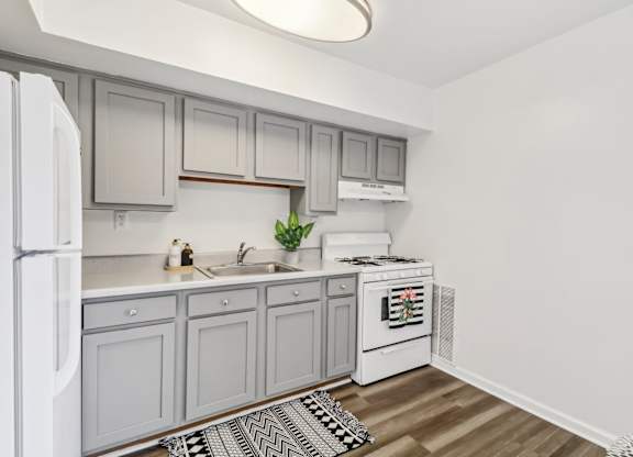 a white kitchen with white appliances and white cabinets at Oaks at Oxon Hill, Oxon Hill, Maryland