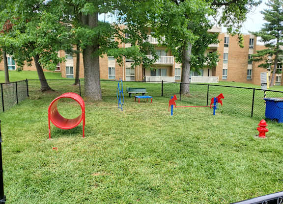 a playground in a park with trees and a fire hydrant at The Glendale Residence, Maryland, 20706