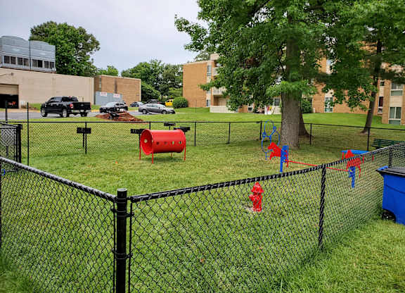 a red fire hydrant in the grass next to a fence at The Glendale Residence, Maryland, 20706