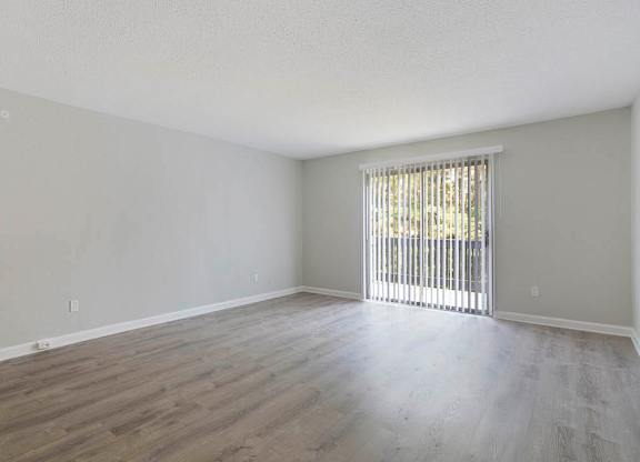 A room with wooden flooring and a window with blinds at The Onyx Hoover Apartments, Hoover