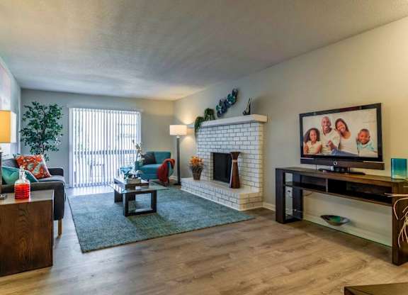 A living room with a fireplace and a television at The Onyx Hoover Apartments, Hoover, Alabama