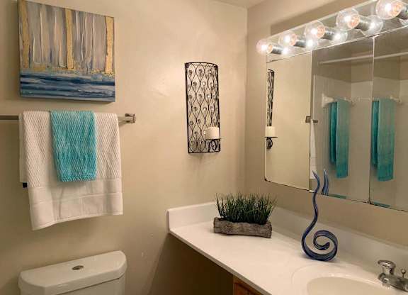 a bathroom with a toilet sink and mirror at The Glendale Residence, Lanham
