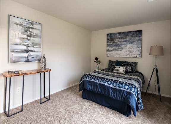a bedroom with a bed and two paintings on the wall at The Glendale Residence, Lanham, MD, 20706