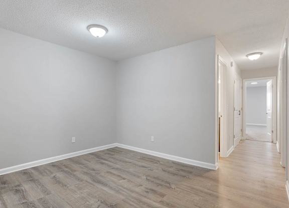 A long hallway with wood floors and white walls. at The Onyx Hoover Apartments, Hoover, Alabama