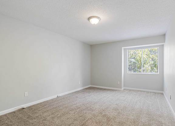 A room with a carpeted floor and a window at The Onyx Hoover Apartments, Hoover