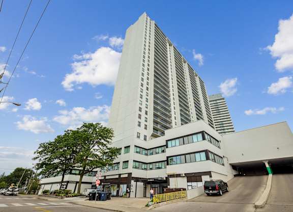 a tall white building with a street in front of it