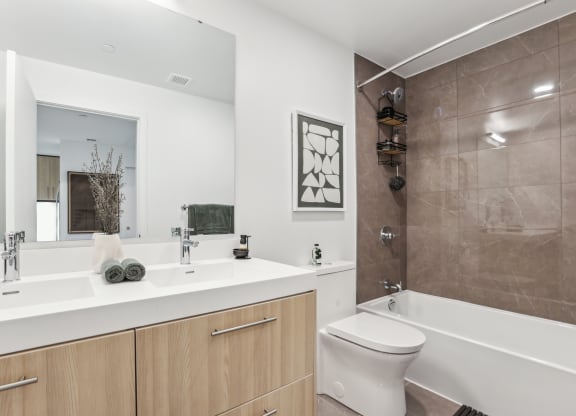 a bathroom with a large mirror and a toilet and a tub