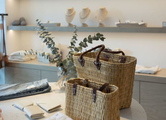 a table with three baskets and a shelf with ceramics on it