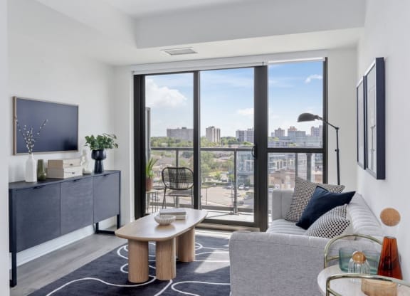 a living room with a view of the city and a couch and a table