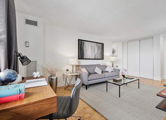 a living room with a couch and a desk and a tv