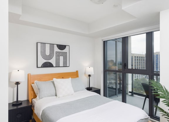 a bedroom with a bed and a large window