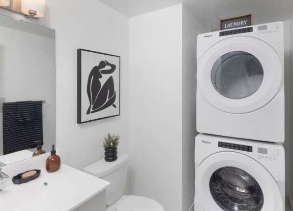 a bathroom with a washing machine and a sink and a geometric wallpaper