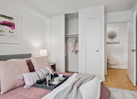 a bedroom with a bed with pink pillows and a tray