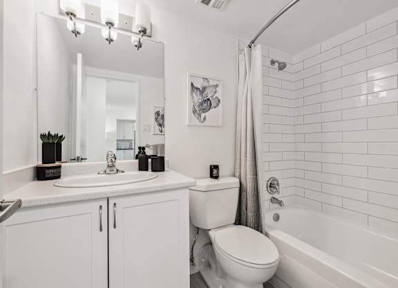 a white bathroom with a shower toilet and sink