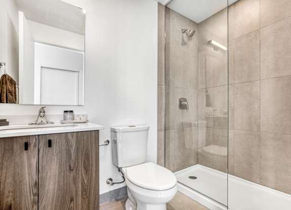 A bathroom with a toilet, sink, and shower.