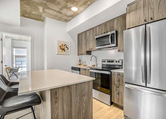 A modern kitchen with a stainless steel refrigerator and a wooden island.