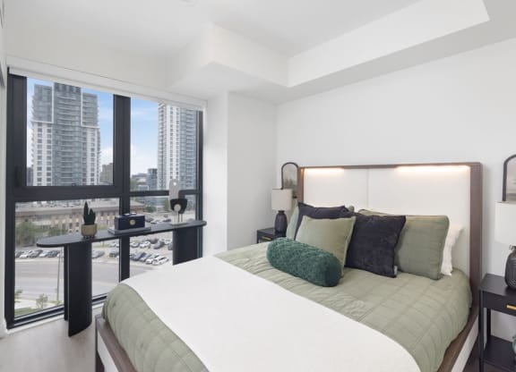a bedroom with a bed and a large window