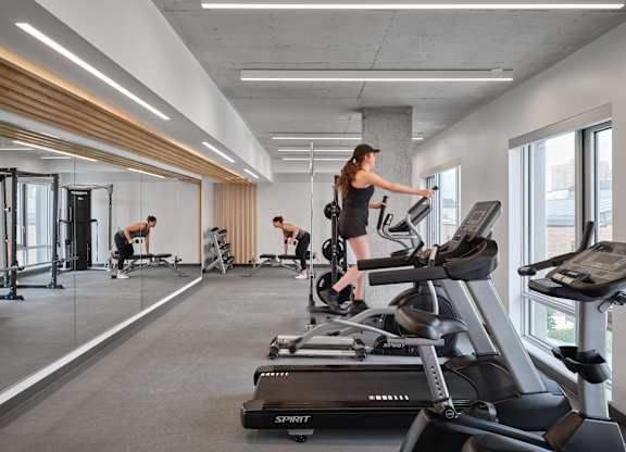 A woman is working out on a treadmill in a gym.