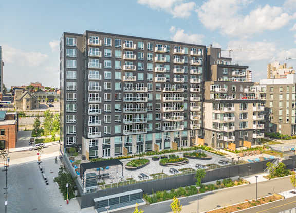 A large, modern apartment building with a courtyard in the front.