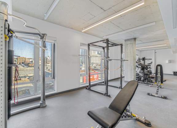 A gym with a view of the city outside the window.