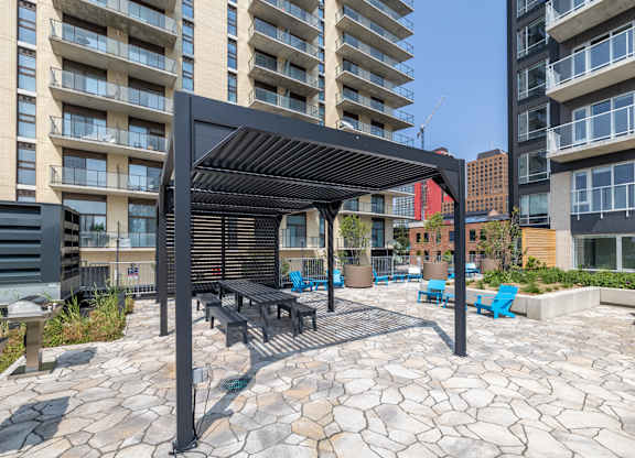 A patio with a table and chairs under a black awning.