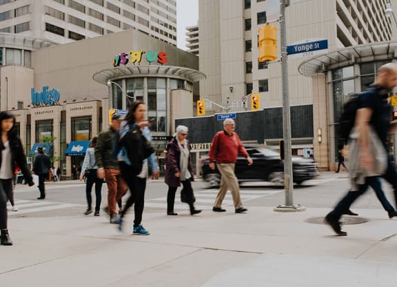 a group of people crossing a busy city street