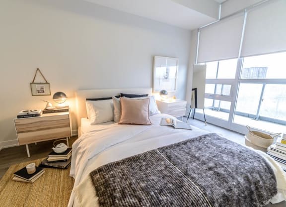 a bedroom with a bed and a large window
