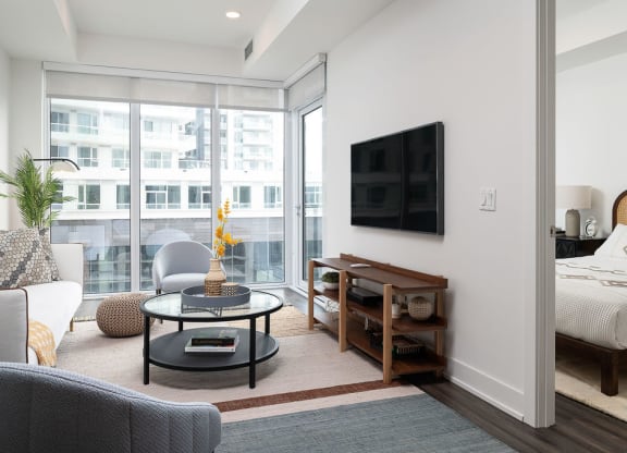 living room with couch, circular coffee table and mounted flatscreen tv