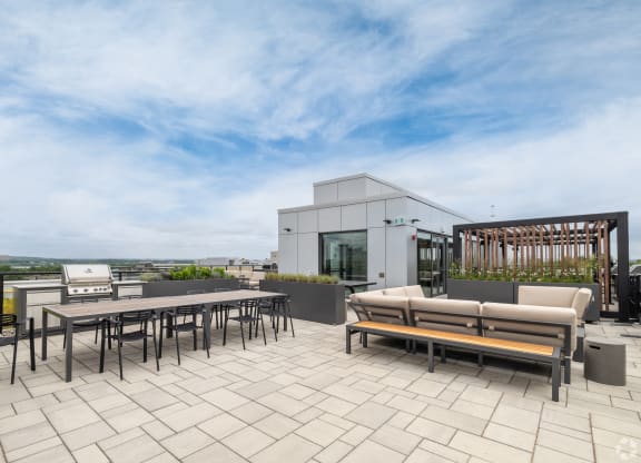 a terrace with tables and chairs and a building in the background
