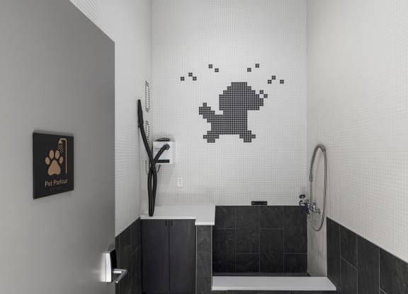 a bathroom with a white tiled wall with a pixelated frog on the wall