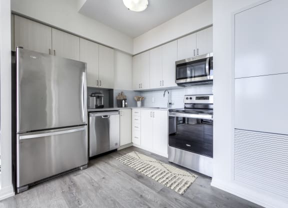 a kitchen with stainless steel appliances and white cabinets