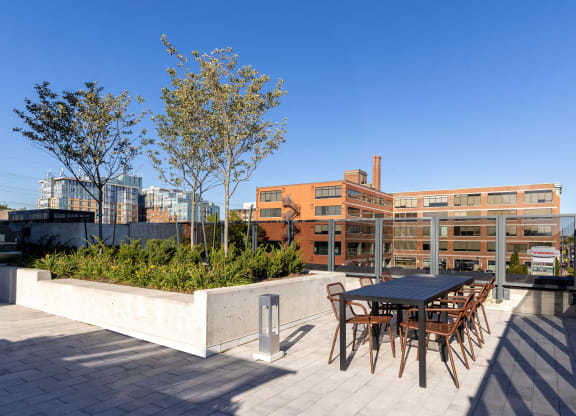 a terrace with a table and chairs and a building in the background