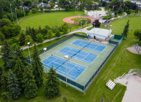 an aerial view of a tennis court on a green field