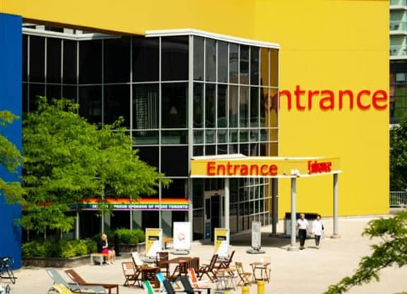 a large yellow convenience store with chairs in front of it