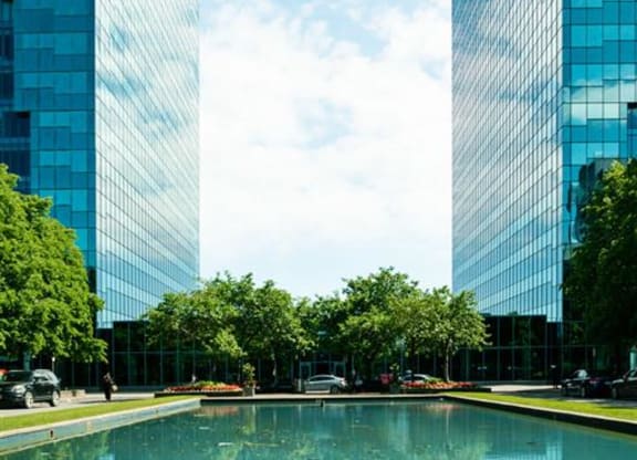 two tall buildings next to a large pool of water