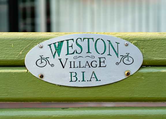 a sign on a green bench that reads bla