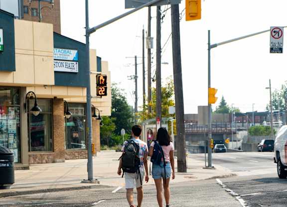 people crossing the street at a crosswalk on a city street