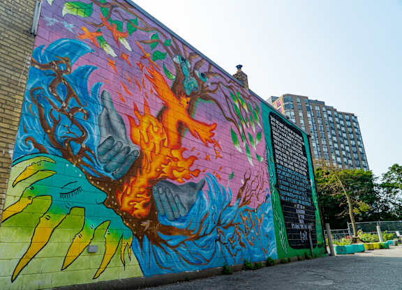 A mural of a flame with a blue background is on a wall.