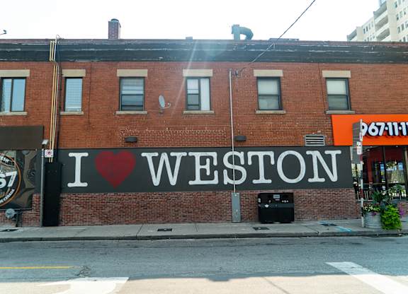 A brick building with a sign that says I love Weston.