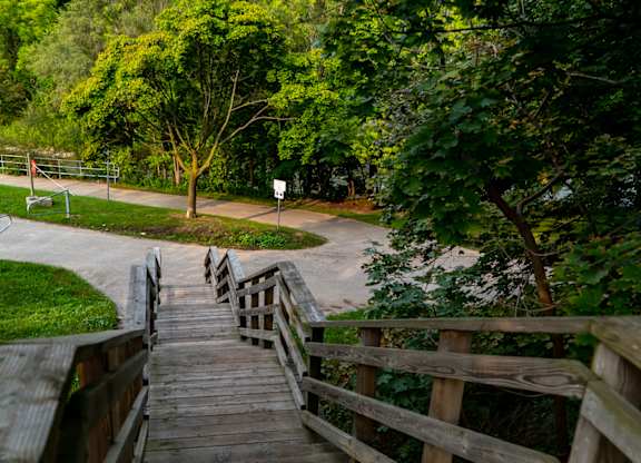 A wooden staircase leads up to a grassy area.