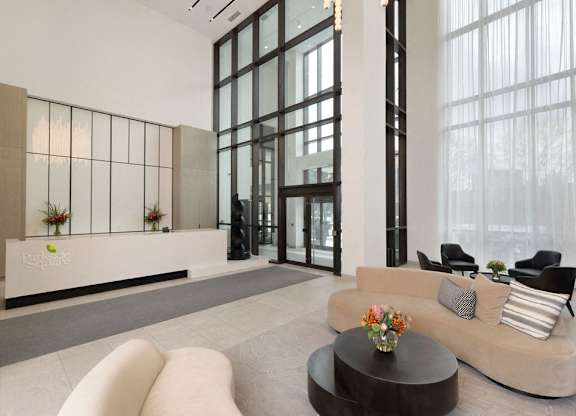A modern living room with a glass door and a black coffee table.