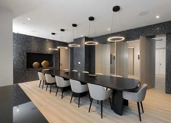 A modern dining room with a black table and chairs.