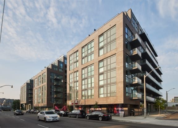 a large brick building with many windows and a parking lot in front of it