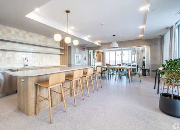 A modern kitchen with a long island and bar stools.