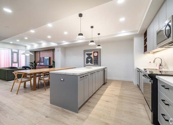 A modern kitchen with a wooden table and chairs.