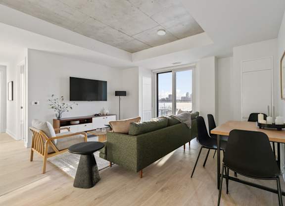 A living room with a green couch and a wooden table.